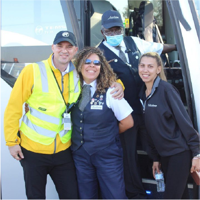 staff posing in front of bus